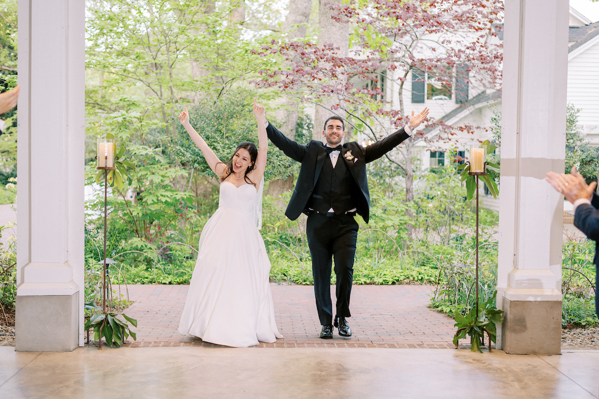 Hannah and Habib with arms raised in celebration