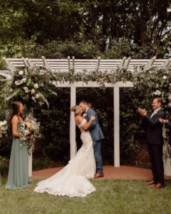 Newlyweds Maggie and Adam have their first wedded kiss in the Fearrington gardens