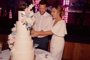 Newlyweds Adam and Maggie slice their wedding cake 