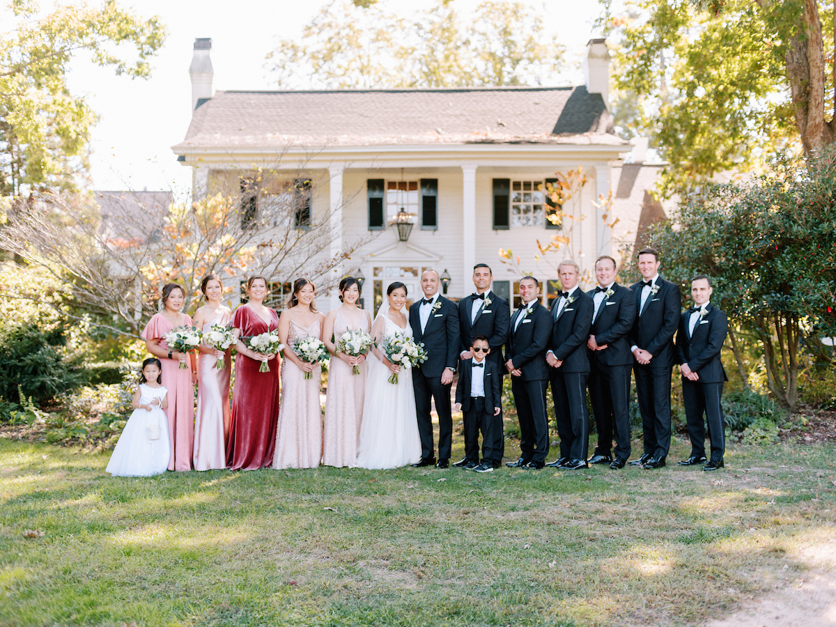 Winnie, Arnie and their wedding party pose in front of the Fearrington House Restaurant